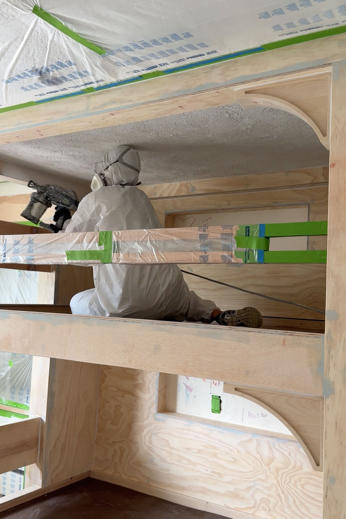 Spraying primer on a DIY bunk bed build.